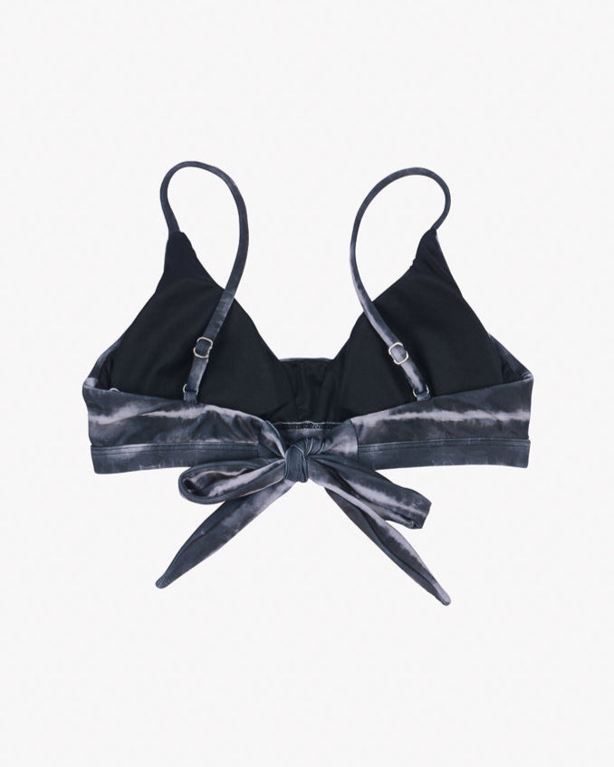 A black Adore Triangel Bikini Oberteil from Main Design with thin, verstellbare Schulterträger and a tie front detail. The tie front and lower band feature a dark grey tie-dye pattern made from umweltfreundlicher Stoff. The background is plain white.