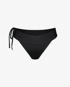 Die Serene Surf Bikinihose von Main Design bietet einen minimalistischen schwarzen Look mit einer Schleife auf der linken Seite für eine verstellbare Passform. Sie ist aus chlorresistentem Stoff und recycelten Materialien gefertigt und ideal als Badebekleidung vor einem schlichten weißen Hintergrund.