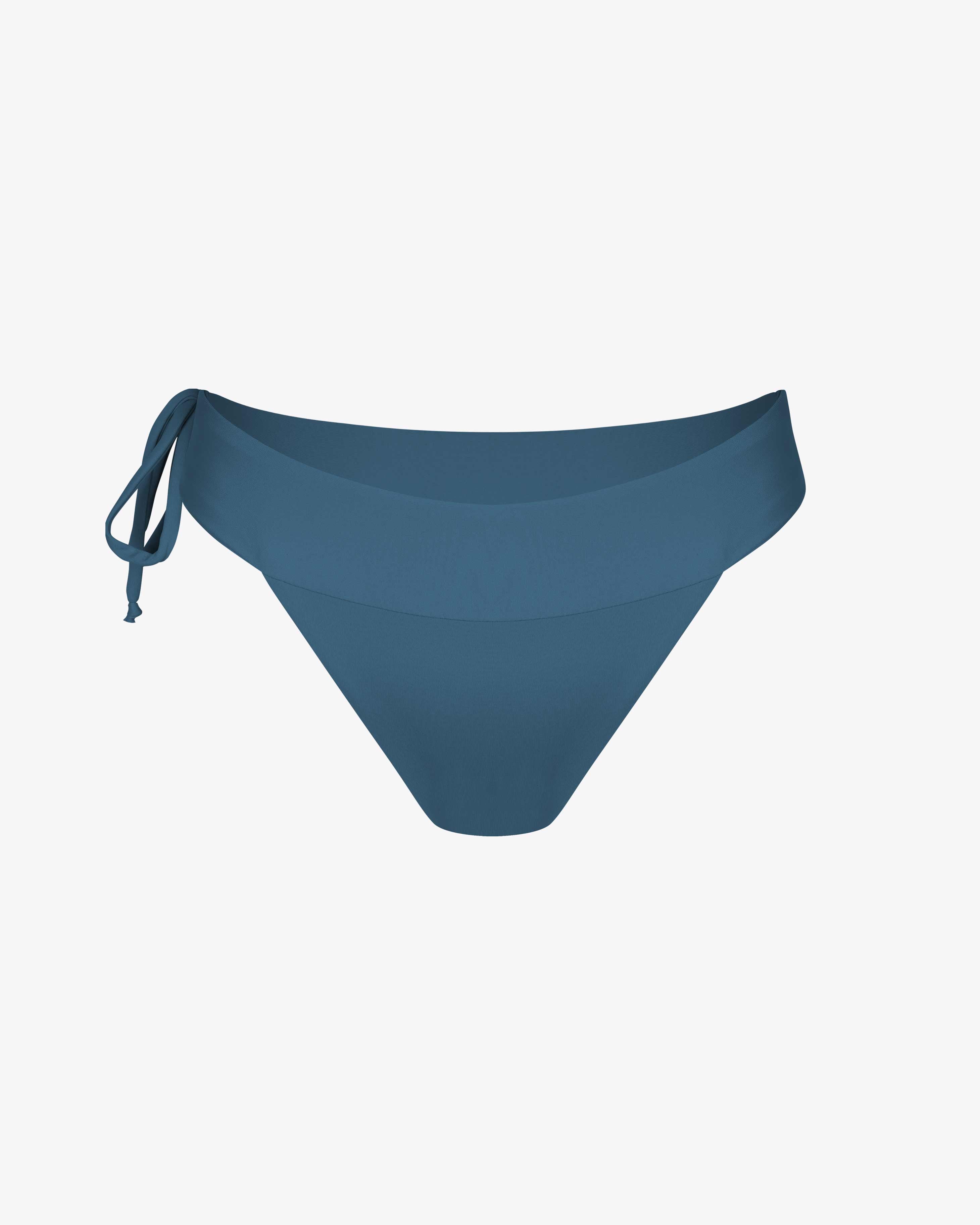 Die Serene Surf Bikini Hose von Main Design hat einen breiten Bund und ein verstellbares Band an der linken Seite. Sie ist aus chlorbeständigem, recyceltem Stoff hergestellt und auf einem einfarbig weißen Hintergrund abgebildet.
