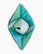 Eine handgefertigte Spielmatte und Krabbeldecke Boot von Main Design, die einer gefalteten geometrischen Blume in Grün und Blau mit blütenblattartigen Schichten ähnelt, die flach vor einem weißen Hintergrund liegt.