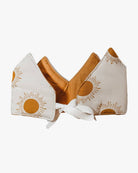 Die Stoffkrone von Several Needs reversibel by Main Design ist handgemacht in Bali, zeigt gelbe Sonnen auf weißem Grund mit Zacken und weißem Band, und ist innen mit fröhlichem Senfgelb gefüttert.