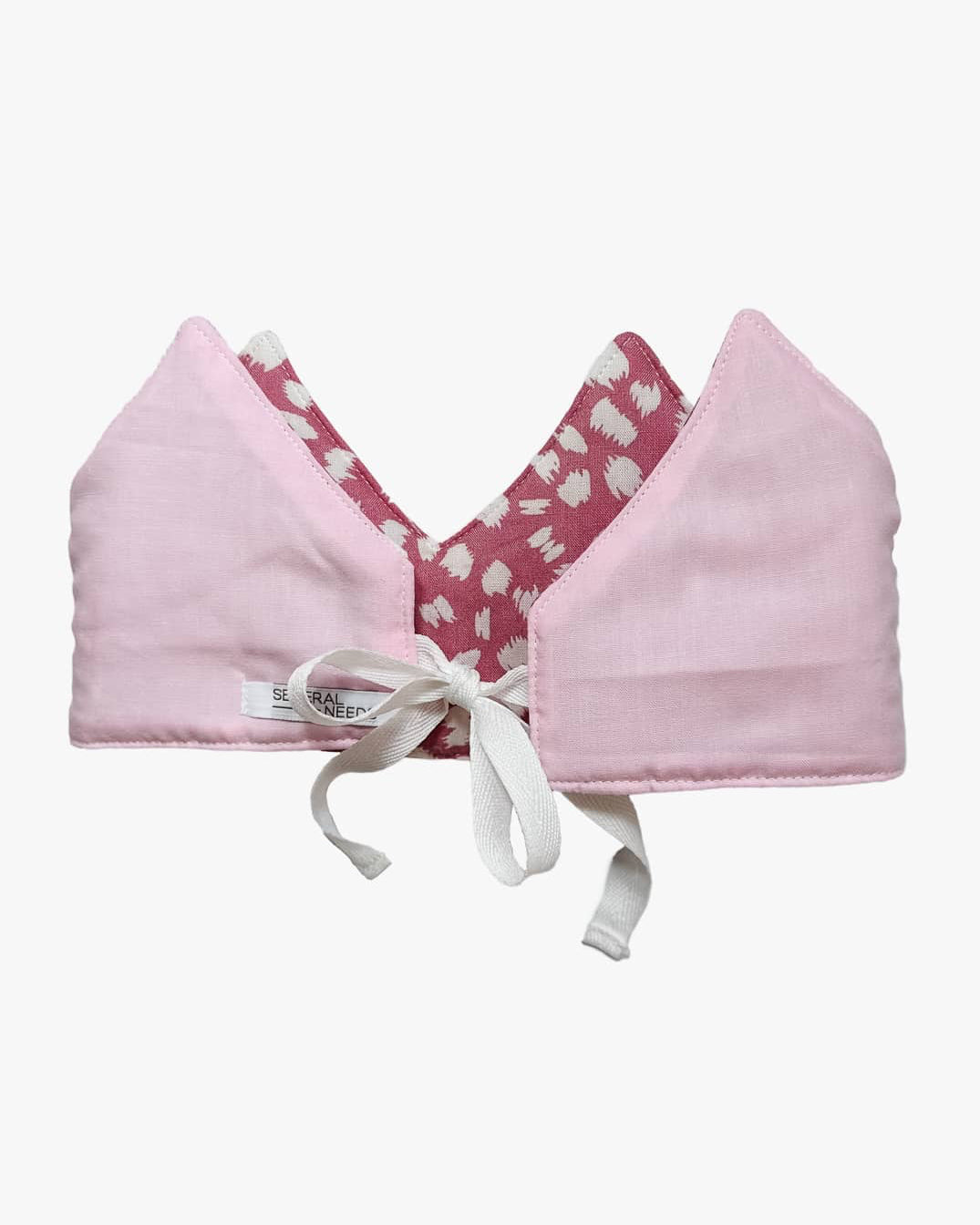 Die Stoffkrone von Several Needs reversibel von Main Design ist eine zartrosa Krone mit spitzen Spitzen, magentafarben gemustertem Futter mit weißen Formen und vorne gebundenen weißen Schleifenbändern. Handgemacht in Bali für Kinder - besonders und einzigartig.
