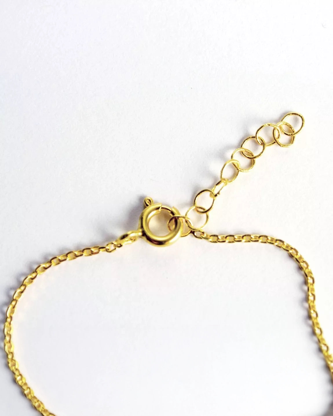 Nahaufnahme des Armbands von Adorabili: Handgefertigt, 24K vergoldet, mit Federring-Verschluss und verstellbarer Verlängerungskette - alles auf weißem Hintergrund.