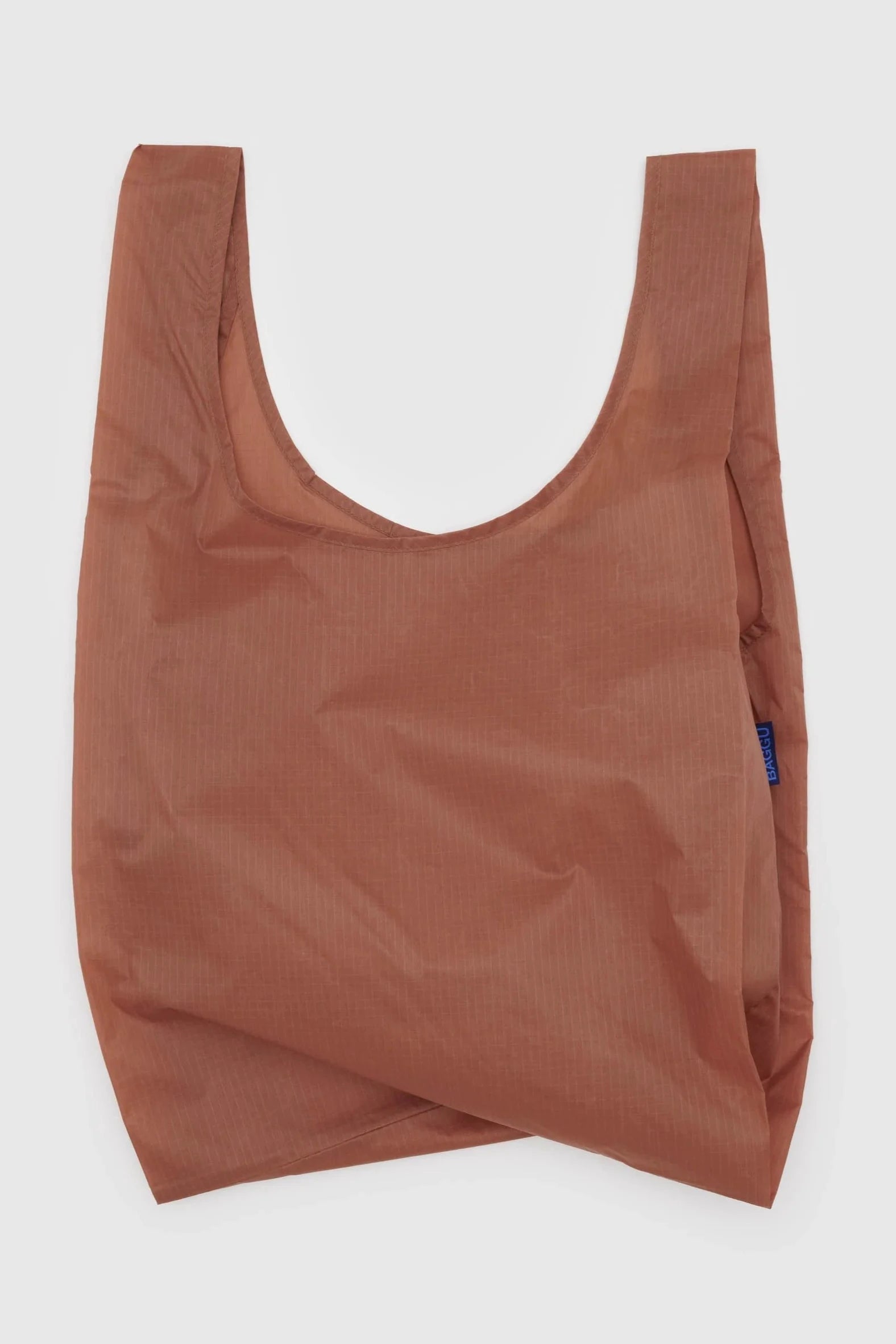 Eine mittelgroße, wiederverwendbare braune Einkaufstasche mit schlichtem Design von Main Design. Die BAGGU Standard Tragetasche ist aus recyceltem Ripstop-Nylon gefertigt, verfügt über zwei große Griffe und bietet eine leichte, aber dennoch robuste Konstruktion, die die Werte eines umweltbewussten Unternehmens widerspiegelt.