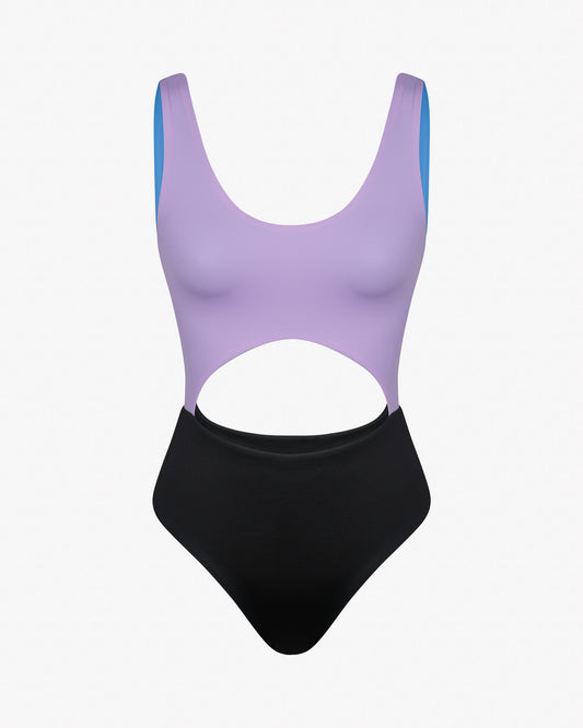 Der Main Design Nova Badeanzug ist ein einteiliger Badeanzug mit lila Oberteil, schwarzem Unterteil, hochgeschnittenen Beinen, markanten Taillenausschnitten, blau gefütterten Trägern und aus chlorresistentem Stoff. Abgebildet auf schlichtem weißem Hintergrund.