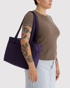 BAGGU Everyday Cloud Bag in Fig: Dunkelviolette Tasche über der Schulter getragen.