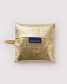 BAGGU Standard Tragetasche in Gold Metallic: Zusammengefaltet im goldfarbenen Metallic-Beutel.