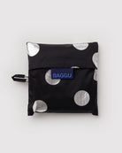 BAGGU Standard Tragetasche in Silver Metallic Polka Dot: Zusammengefaltet im schwarzen Beutel mit silbernen Punkten.